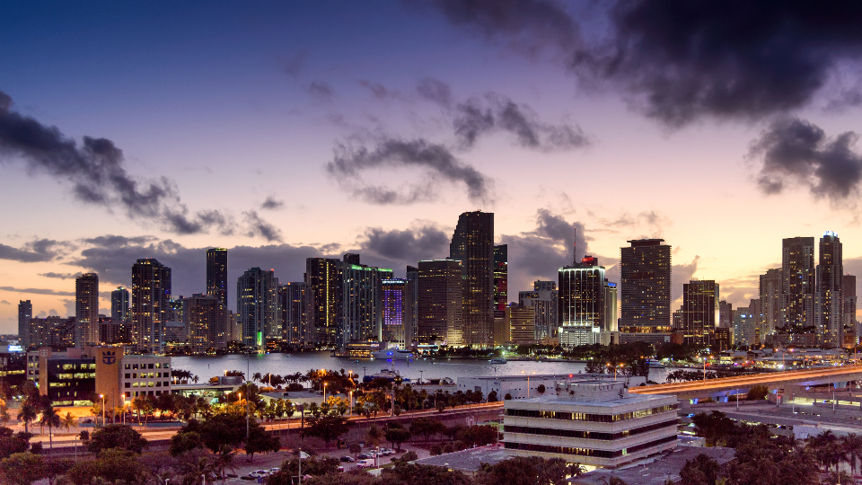 A modern downtown business-district skyline of office towers at dusk, evoking the corporate setting for a Nitaqat Saudization compliance audit for teams relocating into Saudi Arabia.