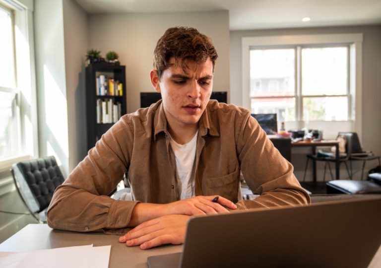A remote professional working intently on a laptop in a sunlit home office, illustrating the income and remote-work proof behind the UAE's tightened 2026 Virtual Working visa rules.