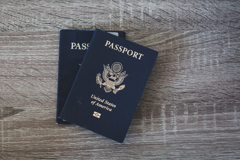 A passport lying on a table, representing the travel documents now logged by Europe's EES and ETIAS biometric border systems that create detailed cross-border travel histories for MENA-Europe business travellers.