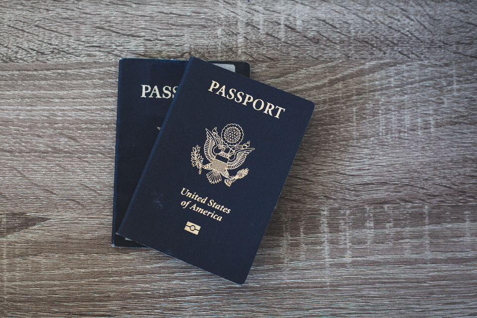 A passport lying on a table, representing the travel documents now logged by Europe's EES and ETIAS biometric border systems that create detailed cross-border travel histories for MENA-Europe business travellers.